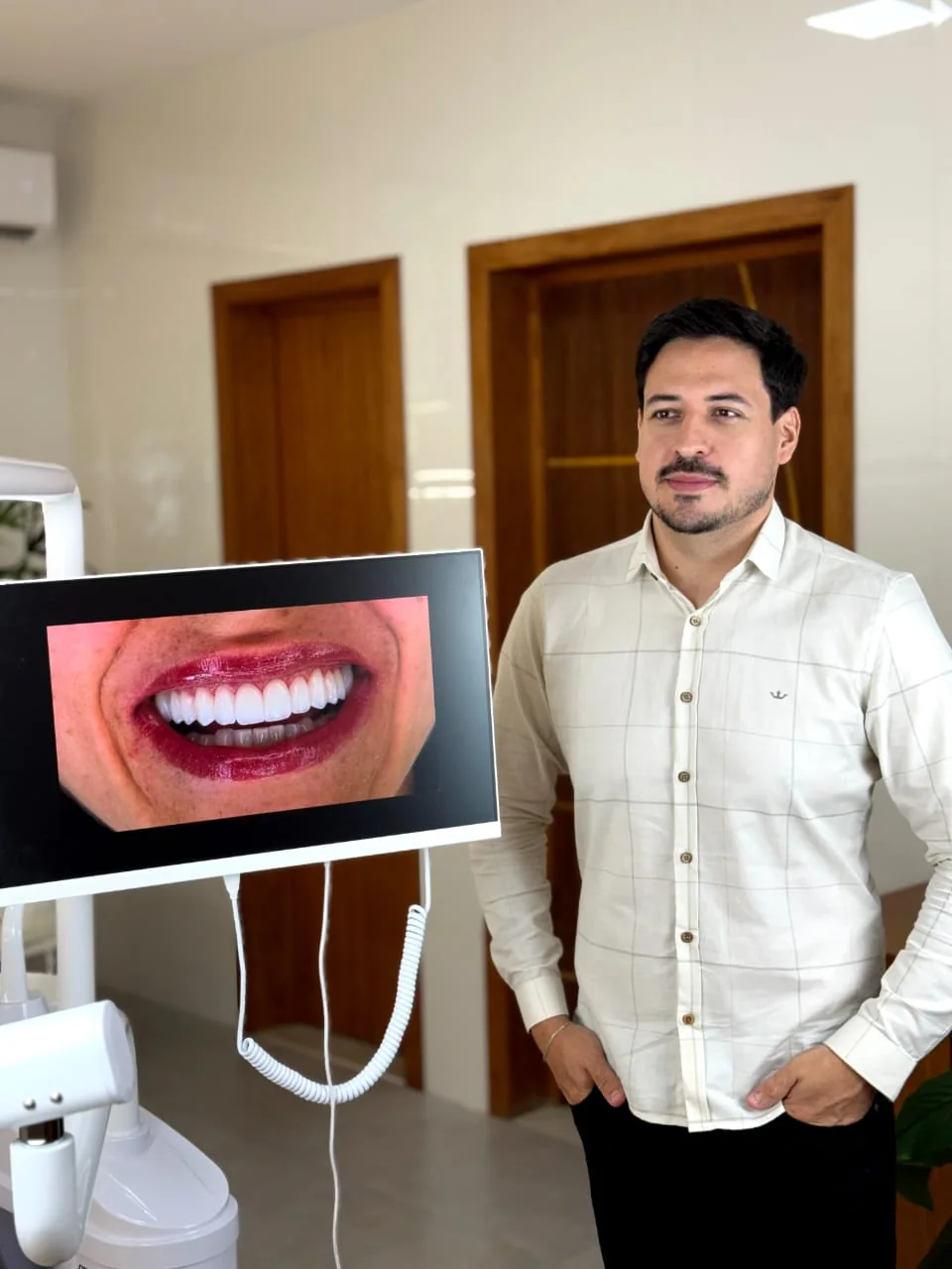 Dr. Rafael Rios ao lado de câmera intraoral e monitor